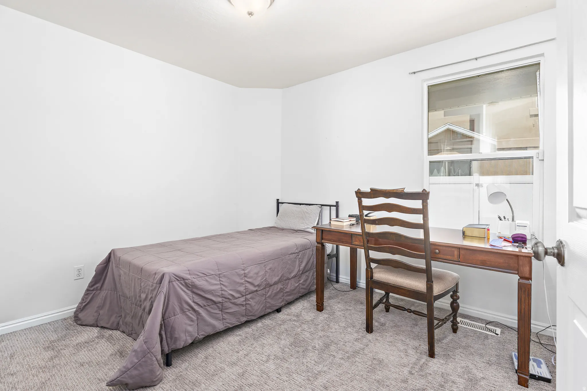 Carpeted interior space featuring white walls and a single window
