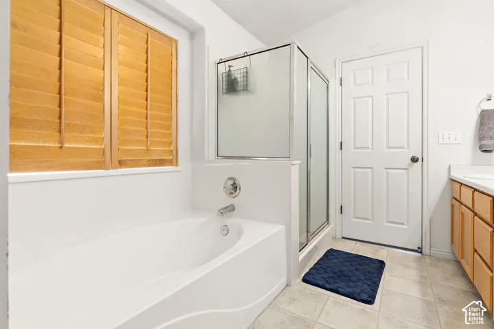 Soaking tub with chrome fixtures and natural wood window shutters