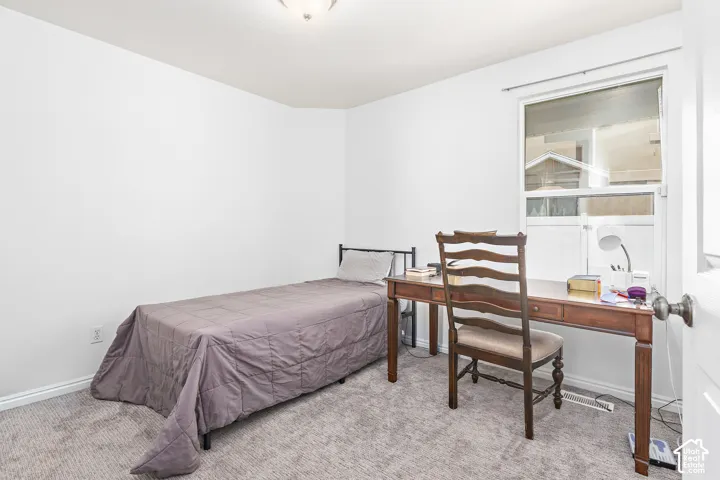 Carpeted interior space featuring white walls and a single window