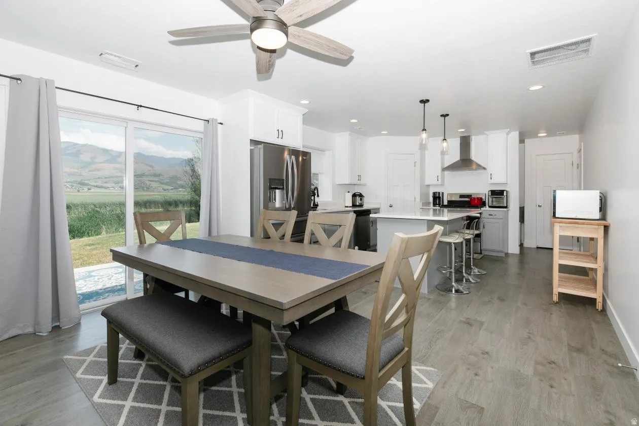 Open-concept living space featuring wood-finish flooring and a contemporary ceiling fan