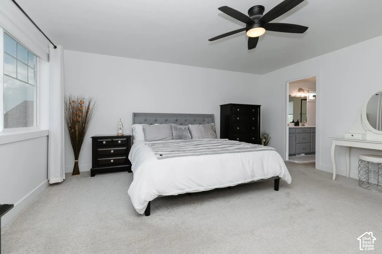 Spacious bedroom with light gray carpeting and white walls