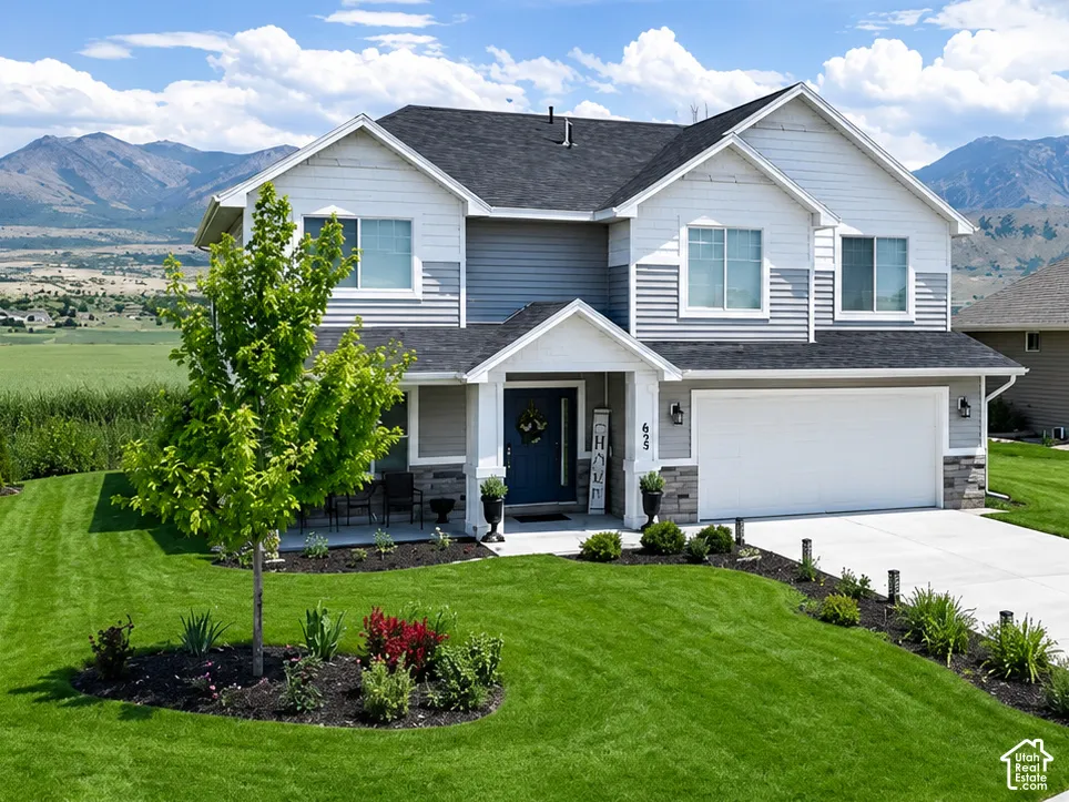 Two-story residence featuring light gray siding, dark gray accents, and a contrasting dark roof