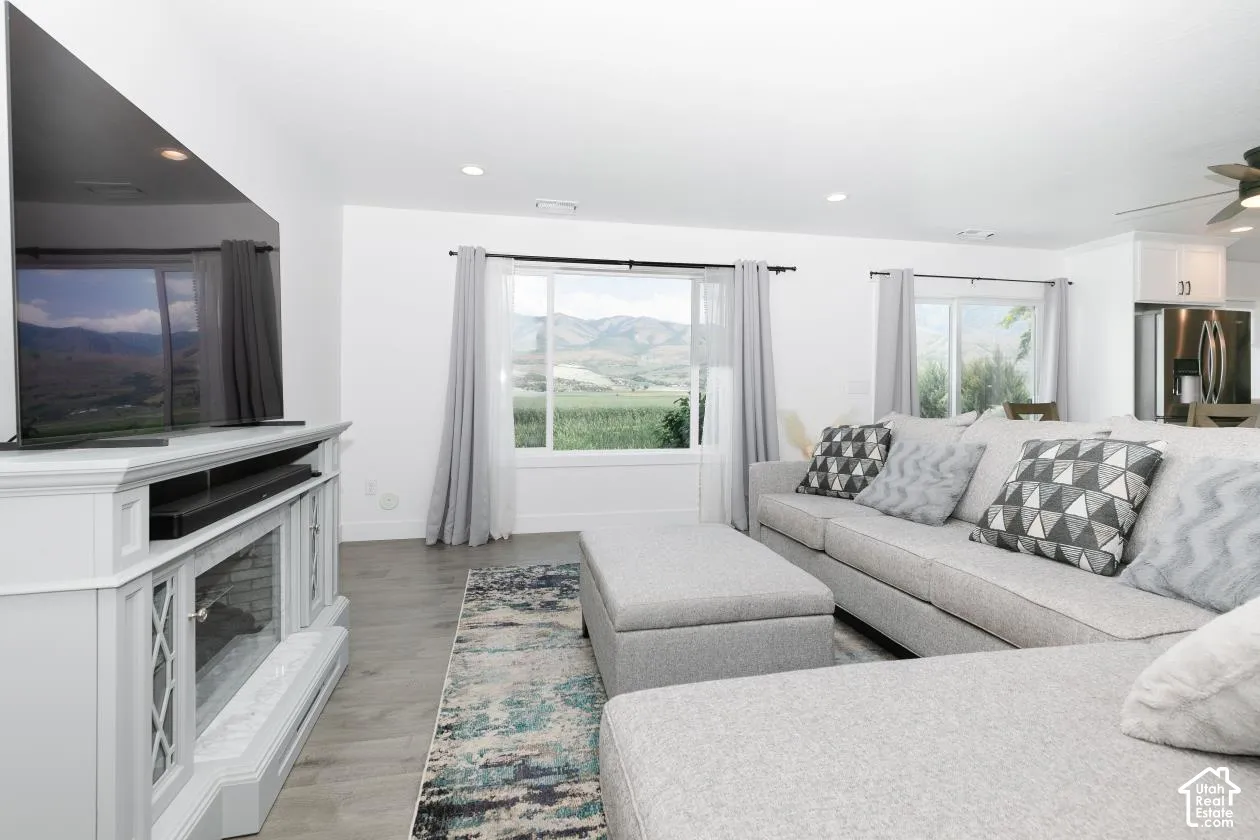 Living area with a  electric fireplace and media console, large windows, lots of light