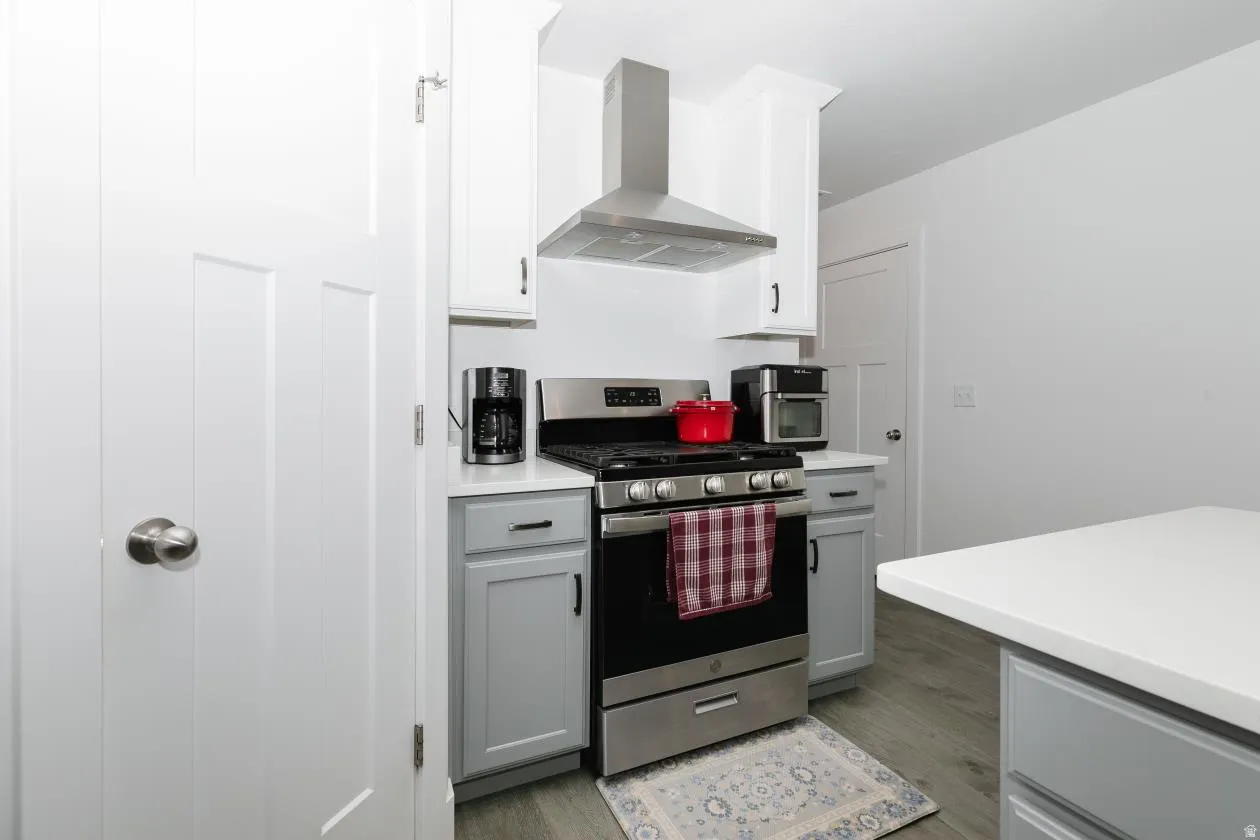 Modern kitchen featuring stainless steel appliances, white upper cabinetry, and contrasting gray lower cabinetry
