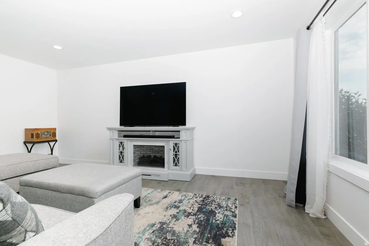 Living area featuring light wood-finish flooring, recessed lighting, and a white baseboard trim