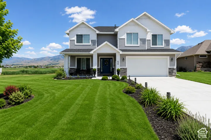 Two-story residence featuring a gray and white exterior with stone accents