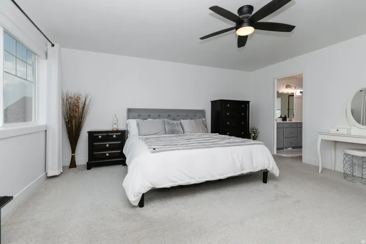 Spacious bedroom with light gray carpeting and white walls