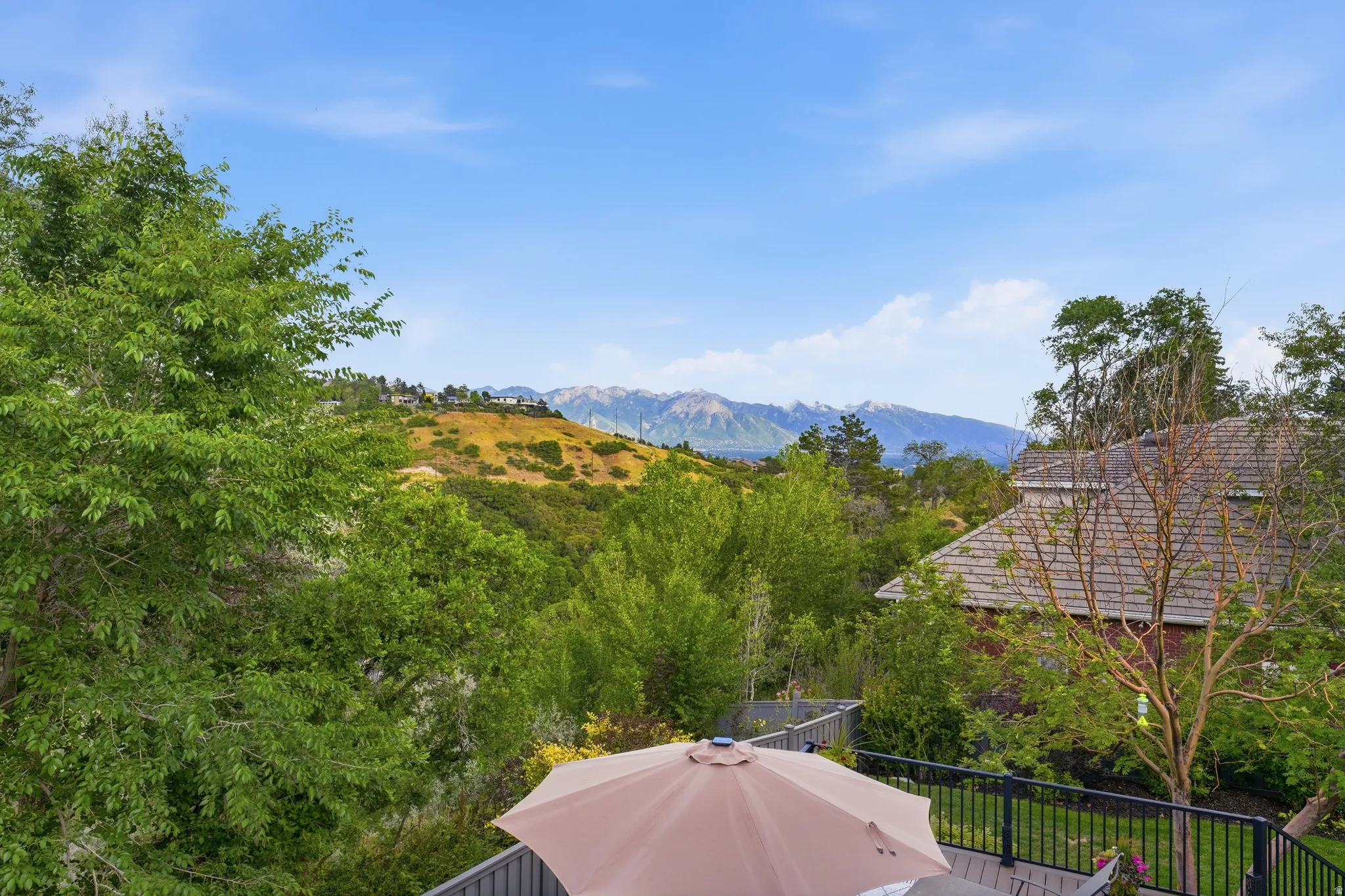 Outdoor deck space with black metal railing and expansive mountain backdrop