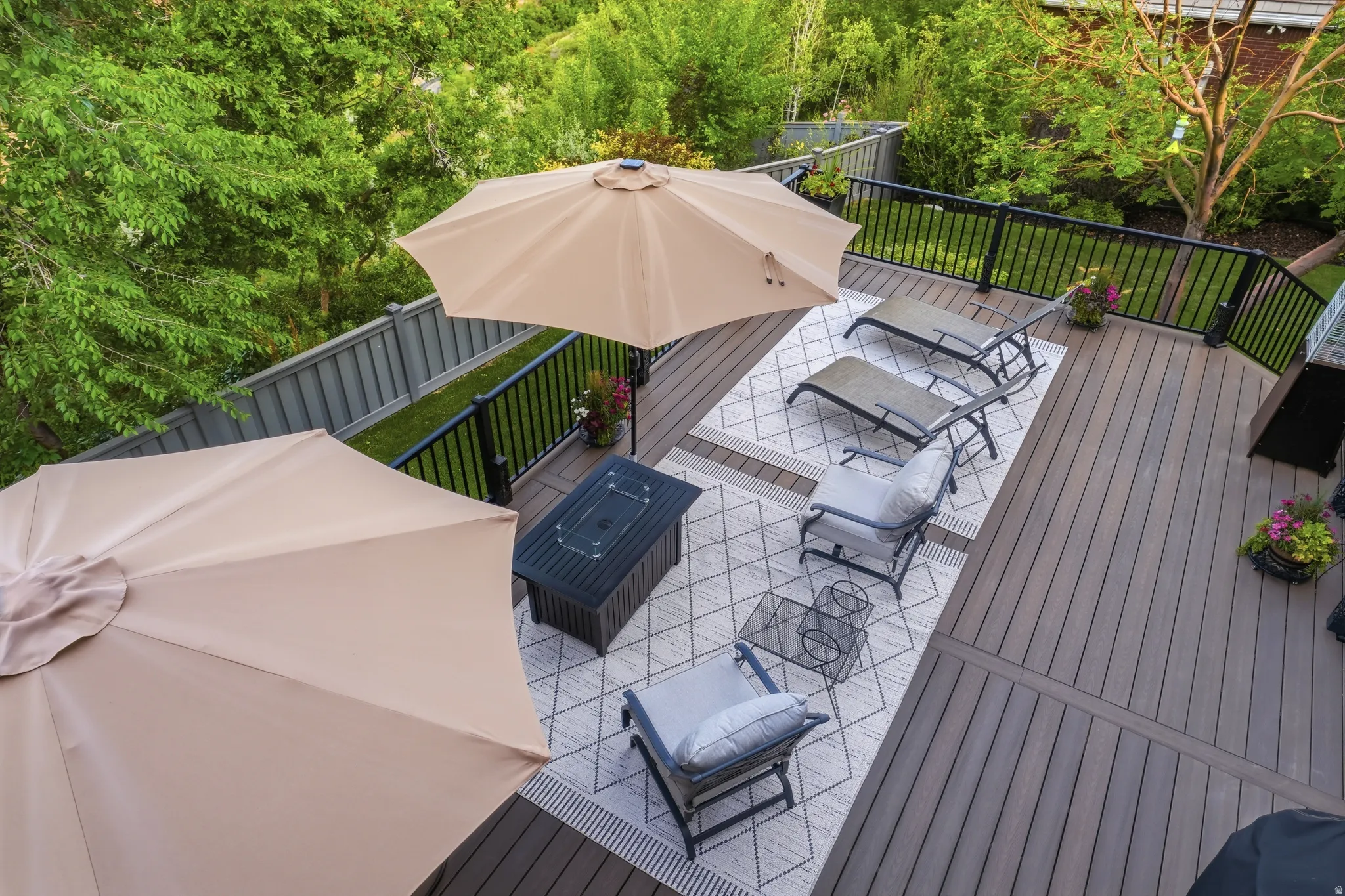 Expansive outdoor deck featuring composite decking, black metal railing, and privacy fencing