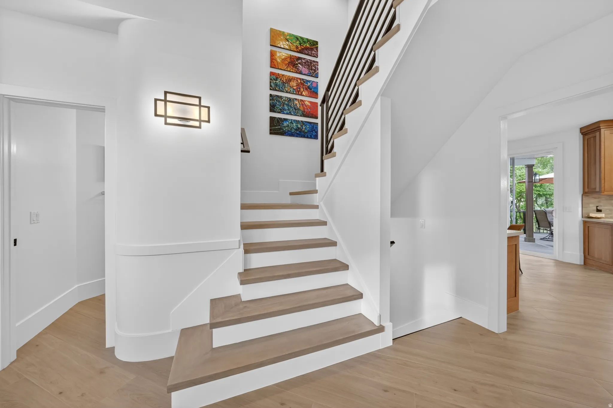Staircase featuring wood-finish treads, white risers, and a contemporary black metal baluster