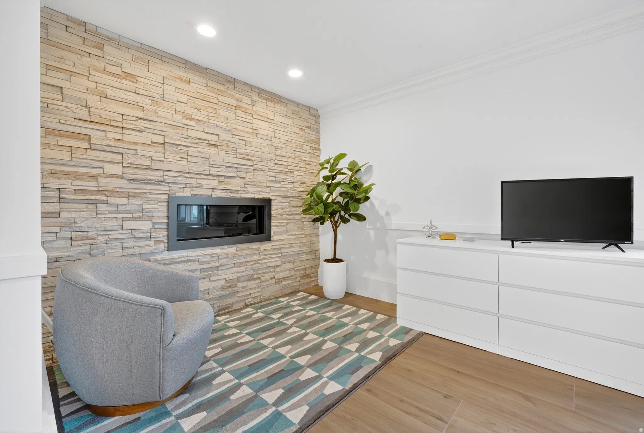 Stacked stone accent wall with an integrated modern fireplace