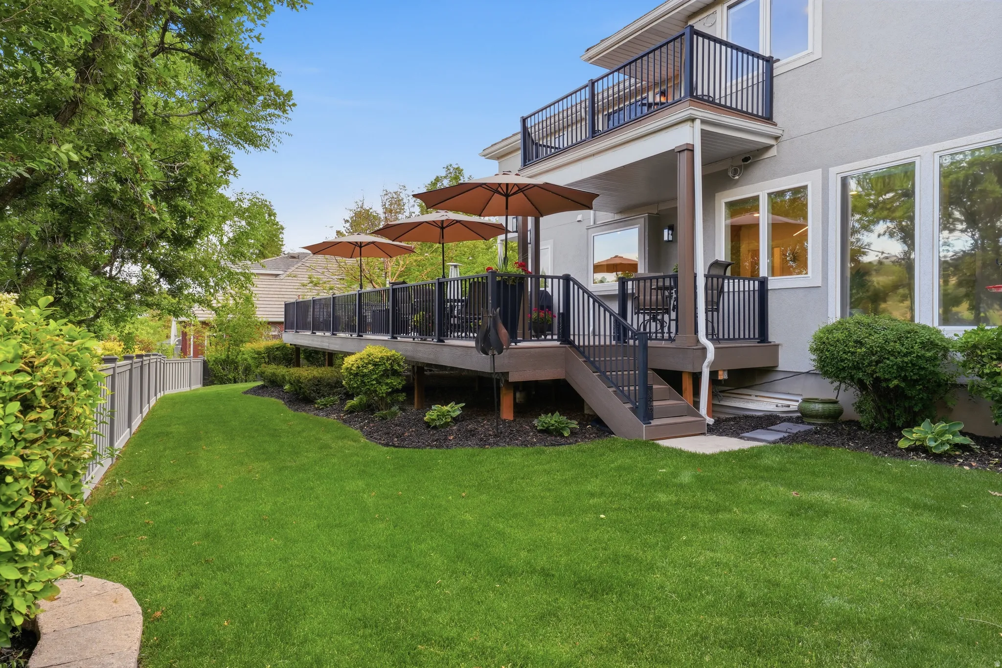 Multi-level exterior deck featuring composite decking and black metal railings