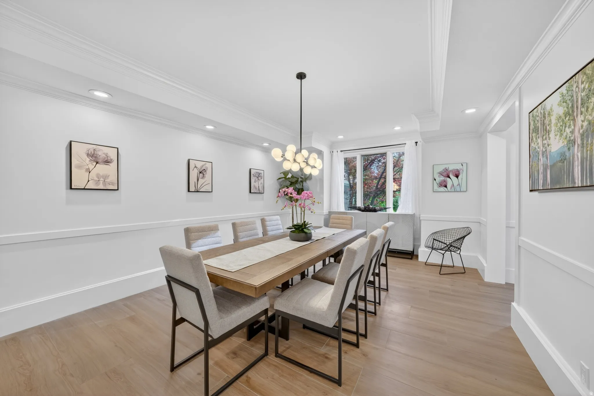 Spacious dining area featuring wood-finish flooring, recessed lighting, and crown molding