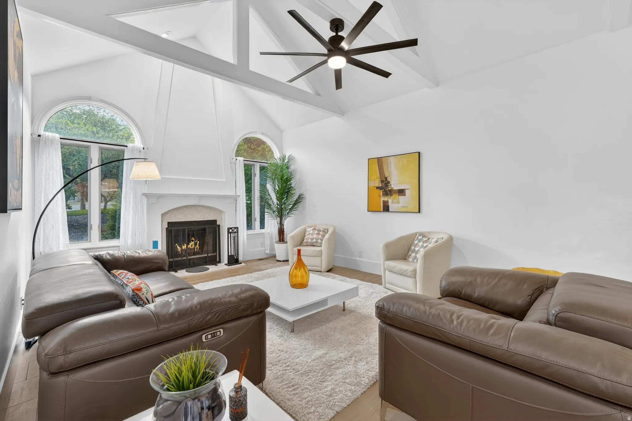 Vaulted ceilings with exposed white beams and a modern ceiling fan