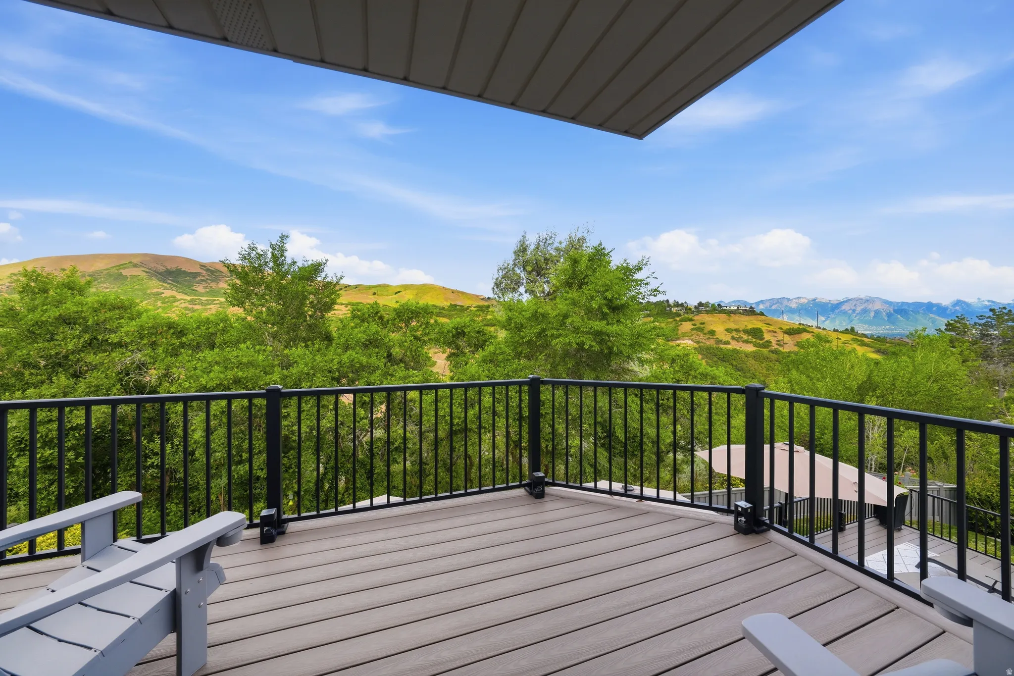 Spacious outdoor deck featuring composite decking and a black metal railing