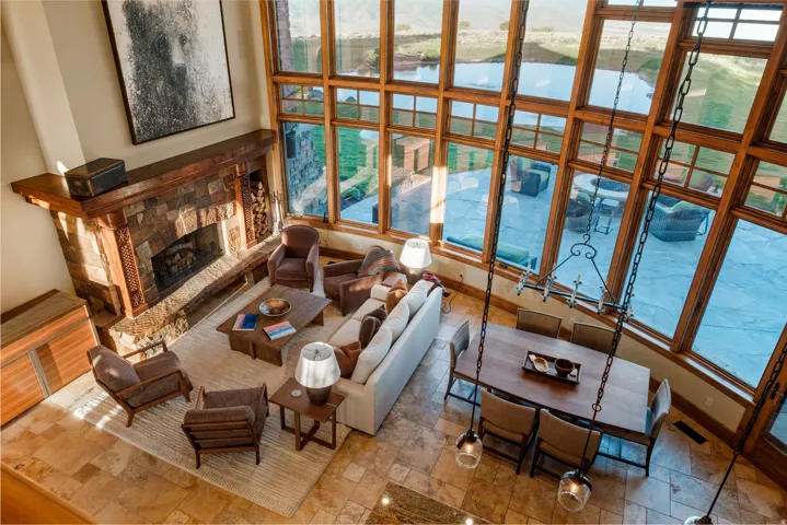 Expansive living area with a stone-clad fireplace and wood mantel