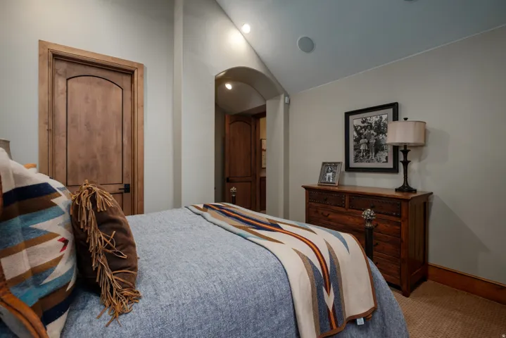 Interior room featuring wood-finish doors with arched top panels, light-colored walls, and recessed ceiling lighting