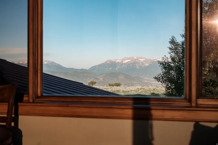 Wood-framed window offering expansive mountain and valley scenery