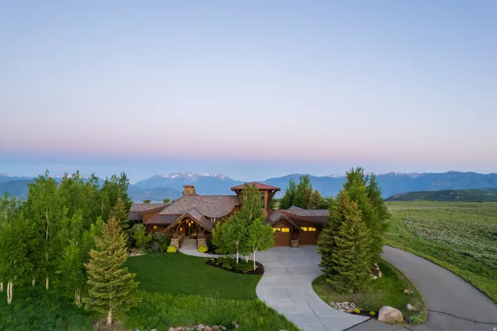 Mountain-style residence featuring a prominent stone chimney and a multi-level architectural design