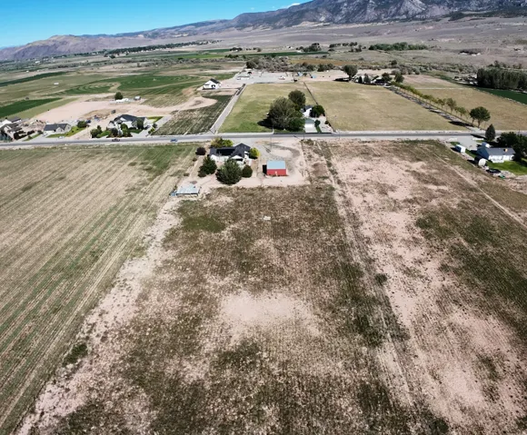 Expansive land with multiple structures, including a primary residence and a red barn