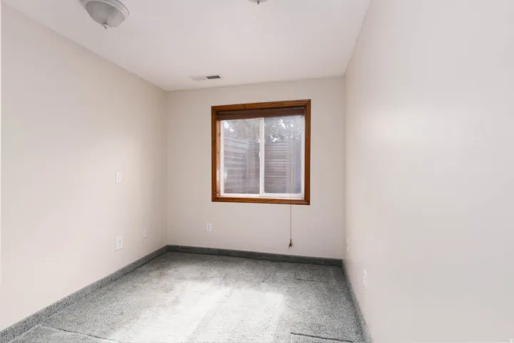 Room featuring light-colored walls and dark gray carpeting
