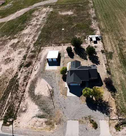 Single-story residence with a dark shingled roof, attached garage, and paved driveway