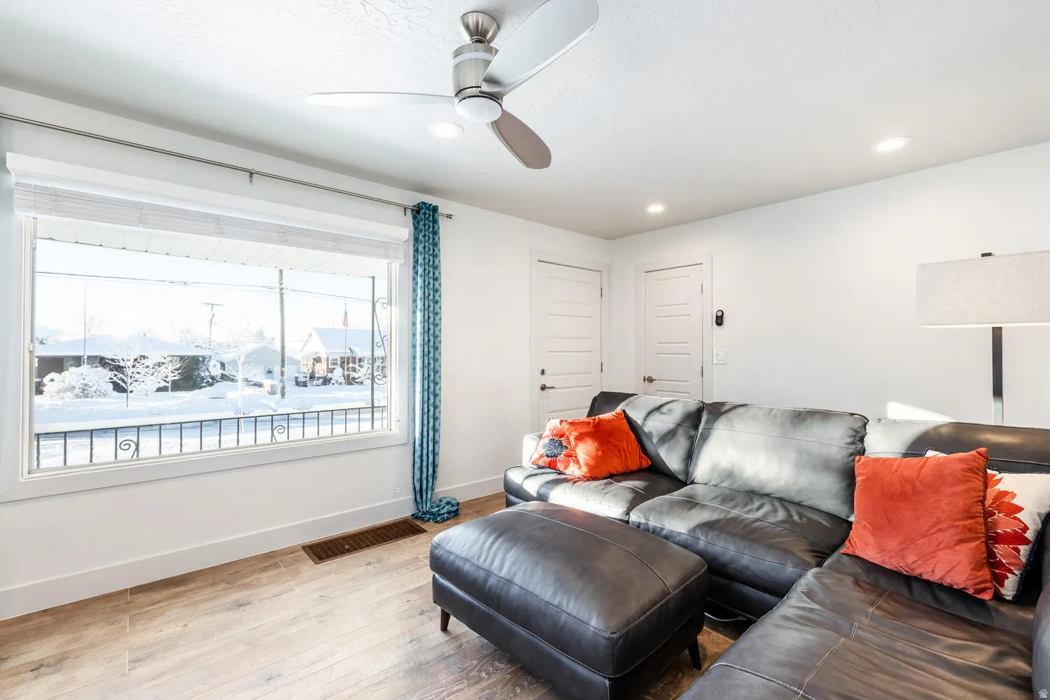 Living area featuring wood-finish flooring, recessed lighting, and a ceiling fan with integrated lighting