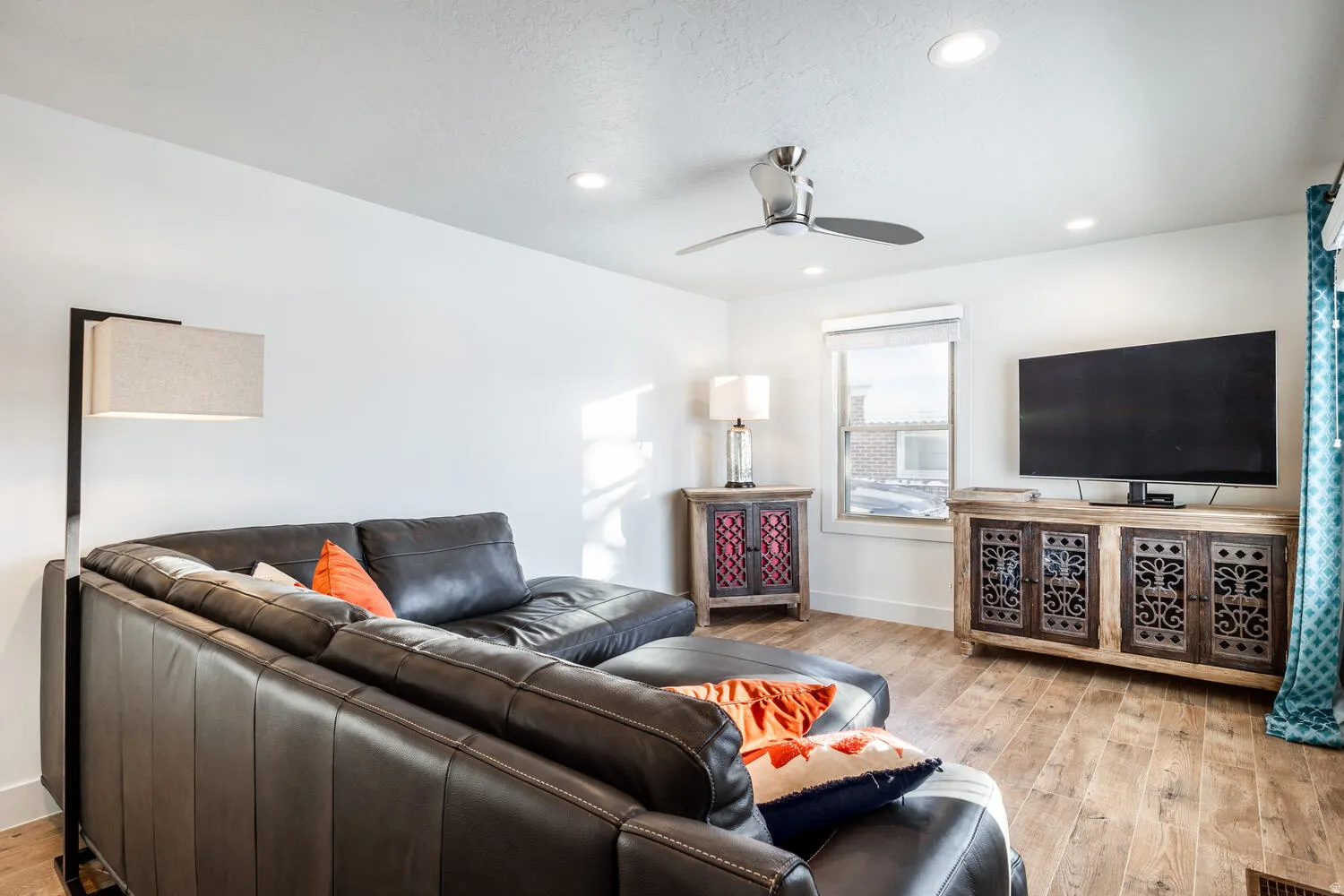 Bright living area featuring wood-finish flooring, recessed lighting, and a ceiling fan