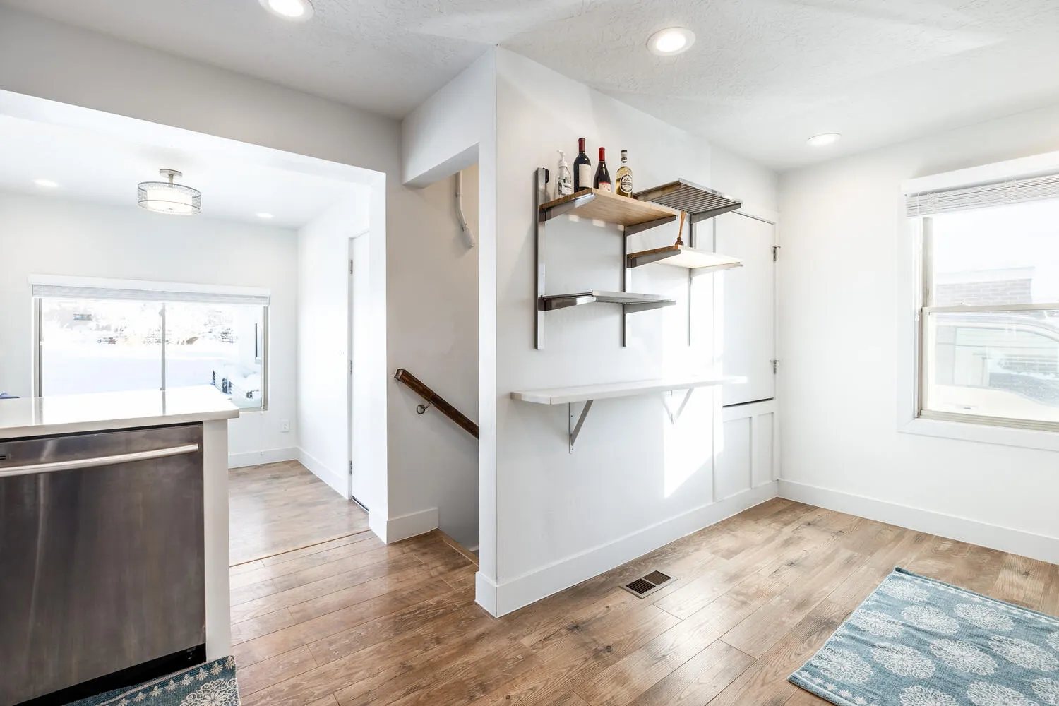 Open-concept space featuring wood-finish flooring, recessed lighting, and a kitchen island with a stainless steel appliance