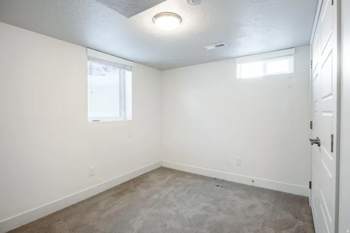 Room featuring light-colored walls and grey carpeting