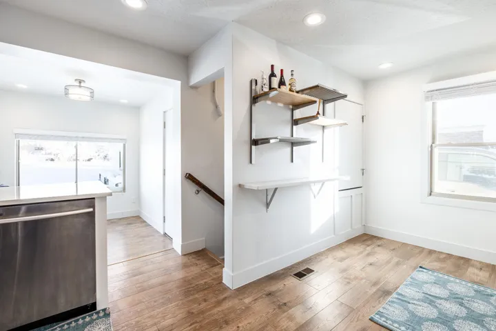 Open-concept space featuring wood-finish flooring, recessed lighting, and a kitchen island with a stainless steel appliance