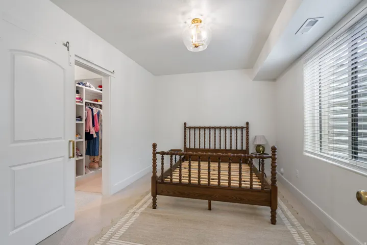 Room featuring a sliding barn door entryway to a custom built-in closet system