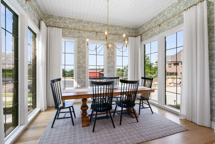 Dining area featuring multiple large picture windows, wood-finish flooring, and a white beadboard ceiling
