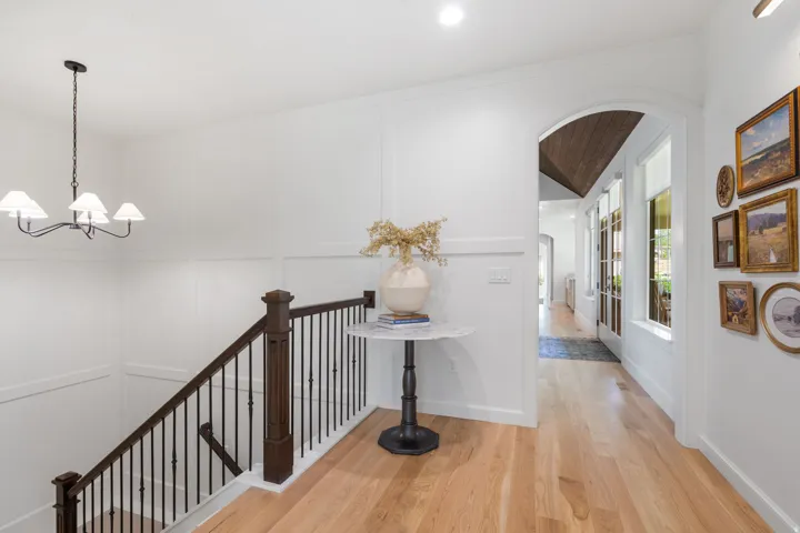 Bright hallway featuring light wood-finish flooring and white wainscoting
