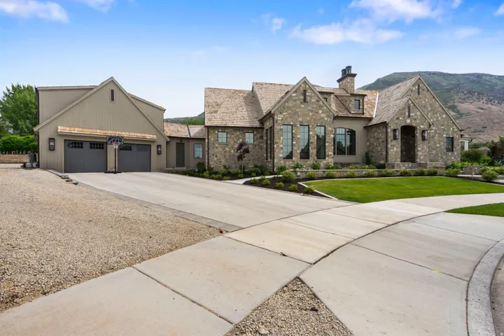 Stone and stucco exterior with a prominent multi-gable roofline and integrated chimney