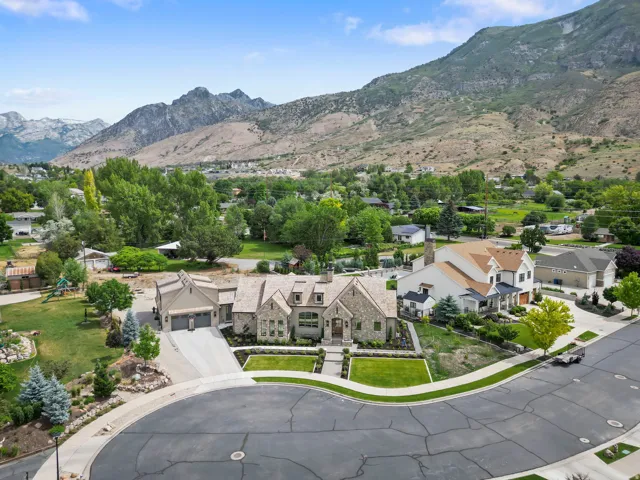 Stone and stucco residence featuring a multi-gabled roofline and attached garage