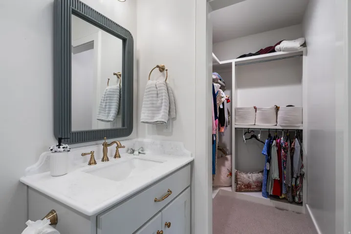 Bathroom vanity featuring a light-toned countertop with an integrated rectangular sink