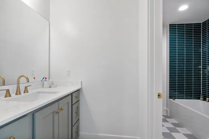 Vanity featuring a stone countertop, an undermount sink, and brass-finish fixtures