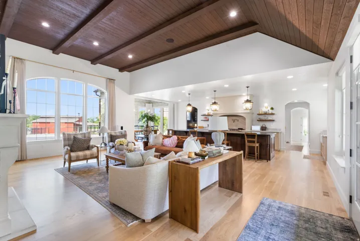 Vaulted ceiling with wood paneling and exposed beams accentuates this open-concept living area