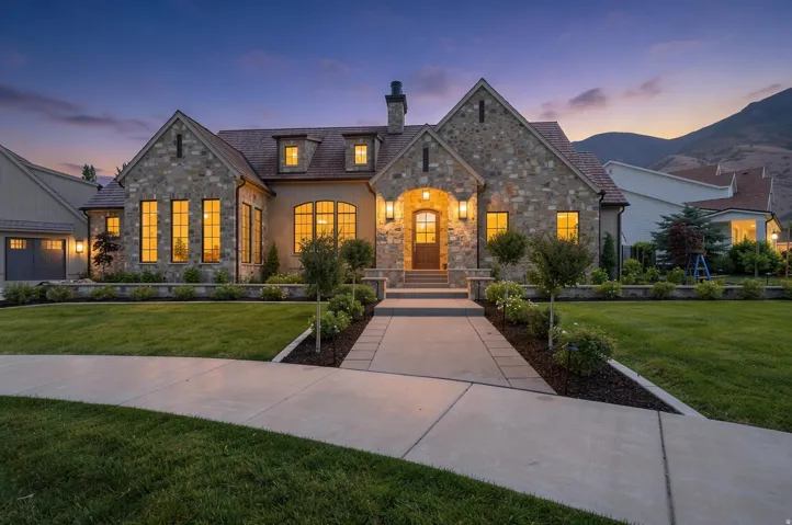 Stone and stucco exterior featuring multiple gables and dormer windows
