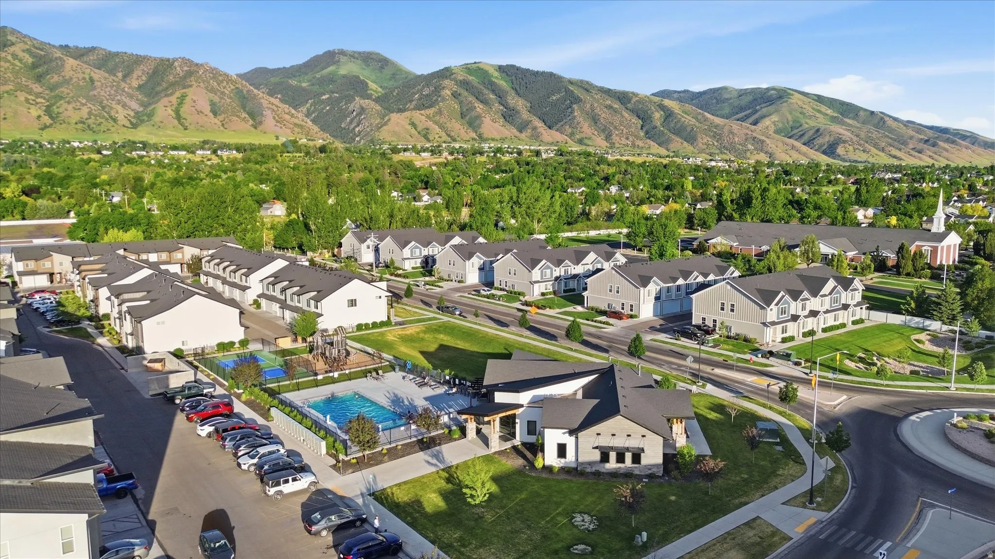 Aerial perspective showcasing a community with a swimming pool, recreational area, and structured townhome residences