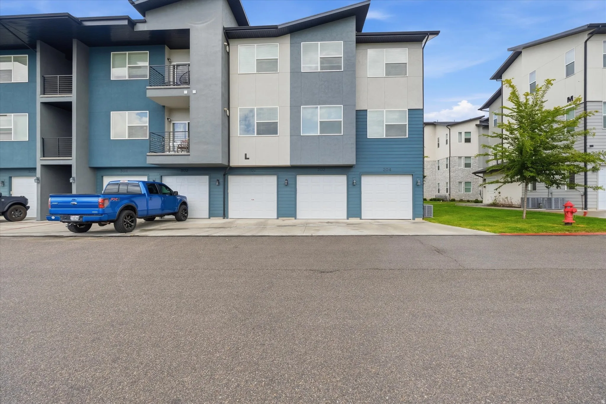 Multi-story residential building featuring a contemporary design with varied exterior siding and multiple private balconies