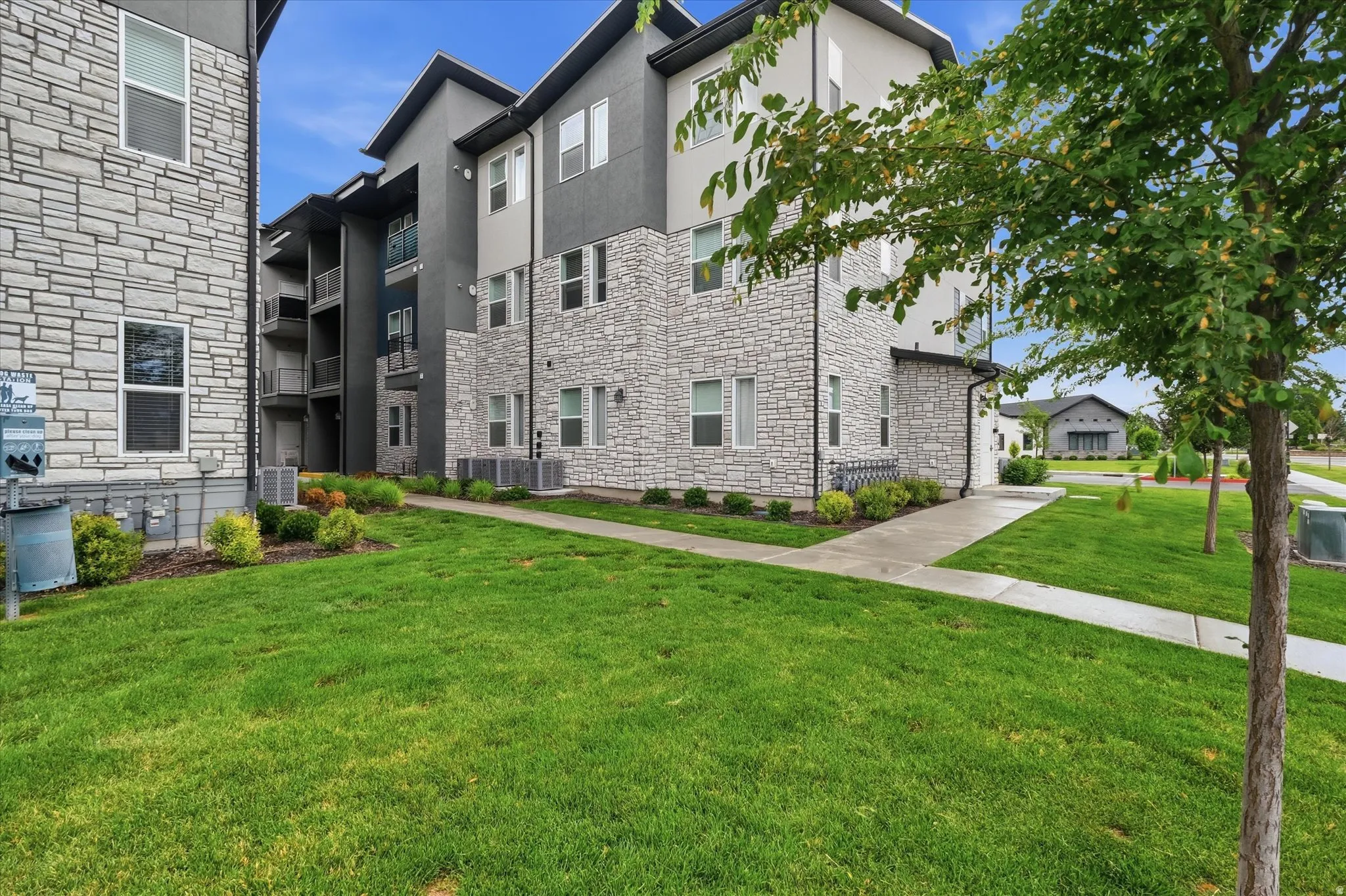Modern multi-story building featuring stacked stone and dark siding with white trim accents
