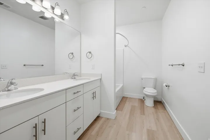 Bathroom featuring a dual vanity with white cabinetry, light-toned countertops, and undermount sinks
