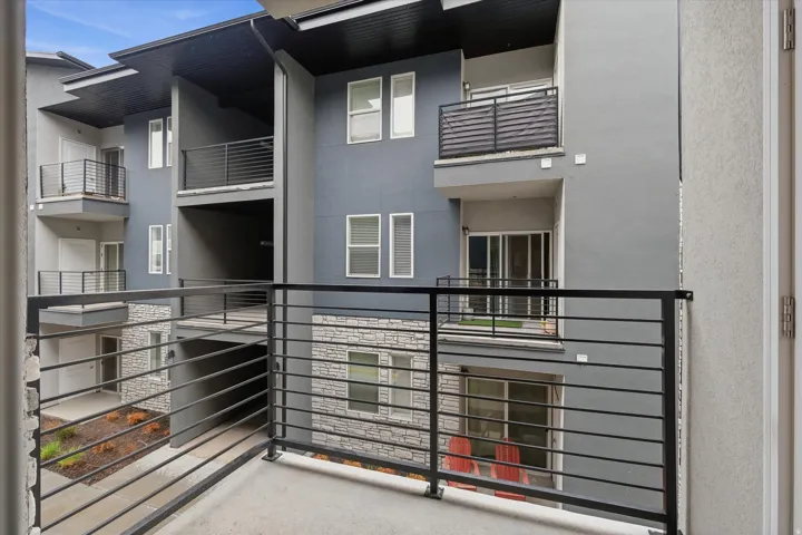 Exterior balcony featuring metal railings and a textured concrete surface