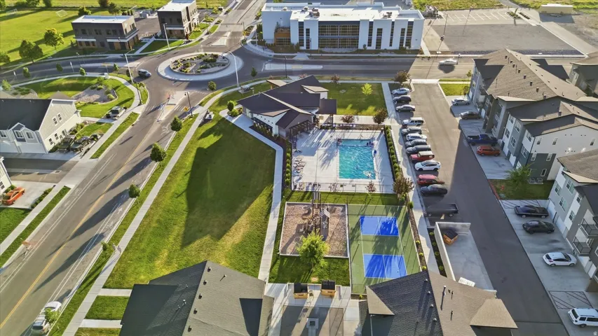 Expansive community grounds featuring a central pool, recreational courts, and a clubhouse