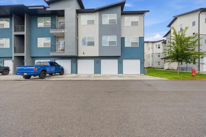 Multi-story residential building featuring a contemporary design with varied exterior siding and multiple private balconies