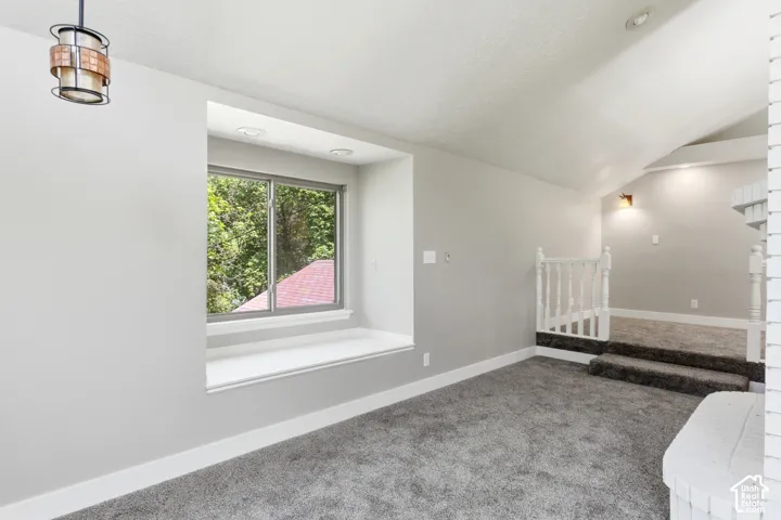Carpeted room featuring a built-in window bench, recessed lighting, and a contemporary ceiling fixture