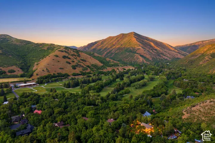 Mountainous terrain with lush green valleys featuring a golf course and residential properties