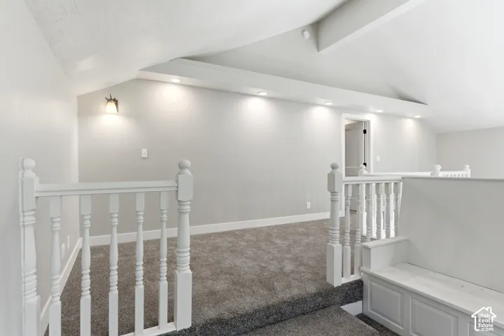 Carpeted loft area featuring white balusters, recessed lighting, a built-in bench, and a wall-mounted sconce